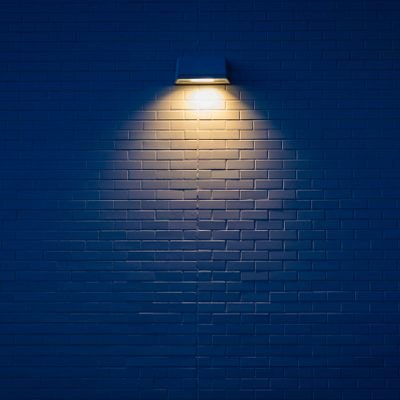Emergency lighting fixture illuminated on a wall